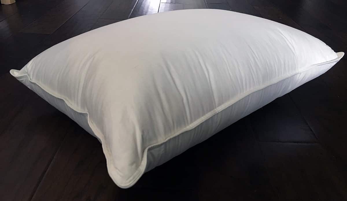 A Brooklinen Down Pillow sits on a dark surface.
